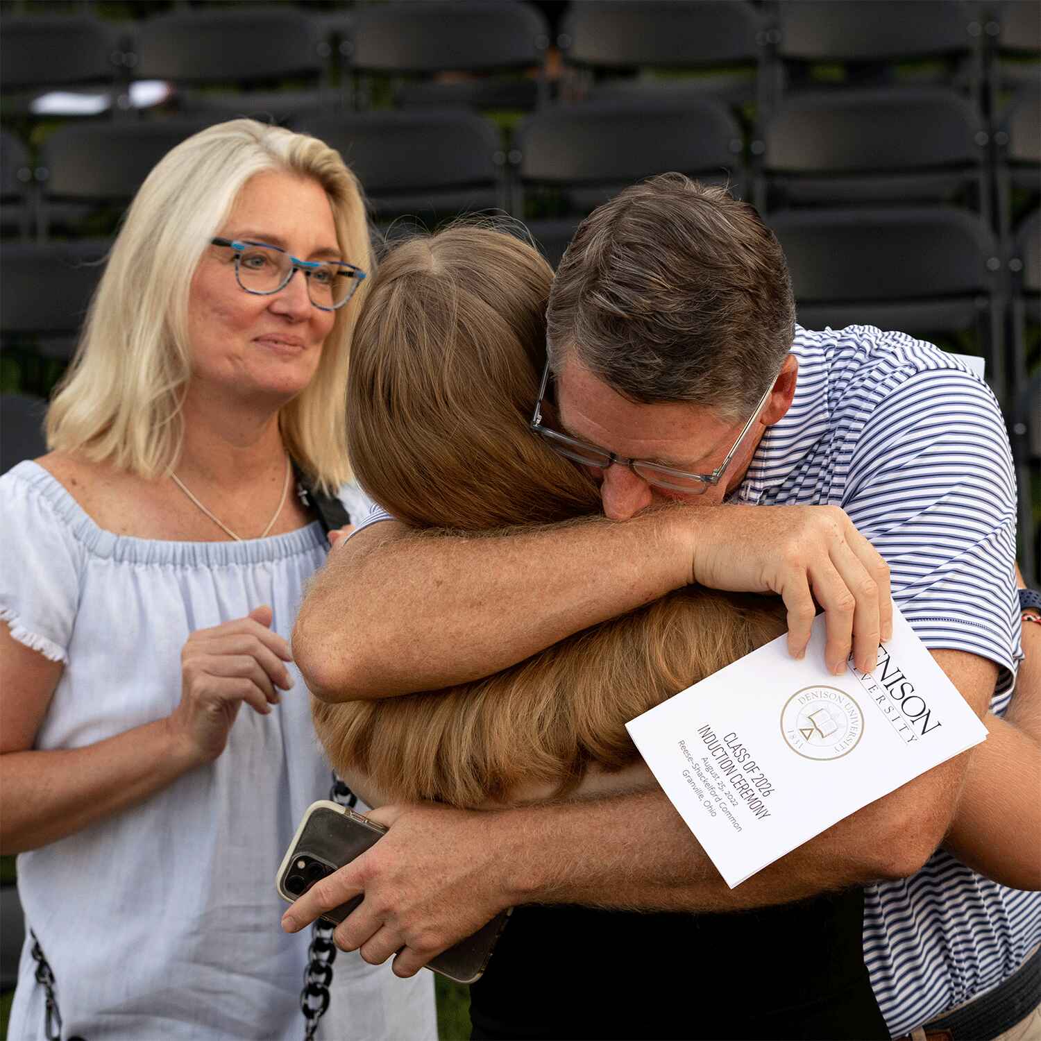 Parents drop their child off at college and hug goodbye