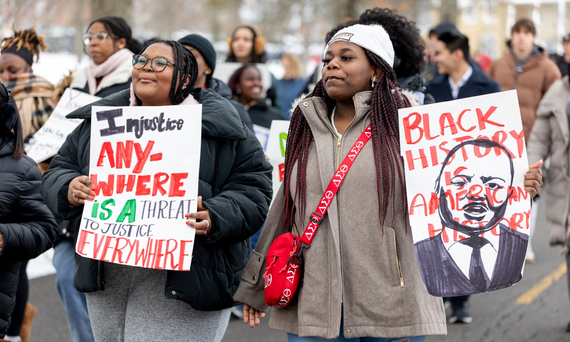 Chloe Echols ’27 and Renai Heath ’25 carry signs during the march to Mitchell Center. 