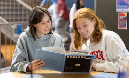 Two women looking at a Denison yearbook. 