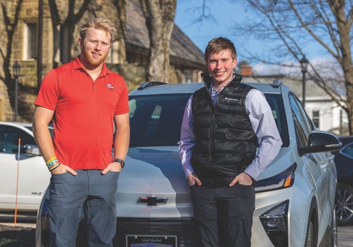 Colin Ravin ’24, left, and Chase King ’24 stand in front of Denison’s new Chevy Bolt.
