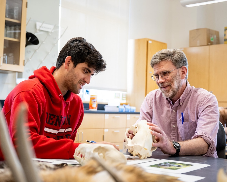 Student with faculty member holding a fossil