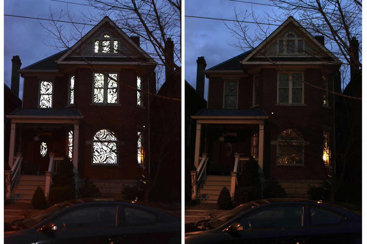 Exterior of house with all lights on next to house with lights off