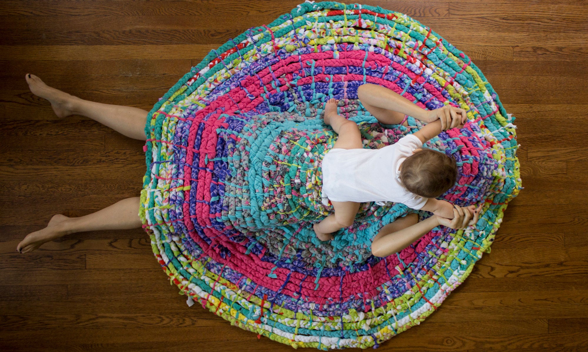 Women under a rug with a baby on top