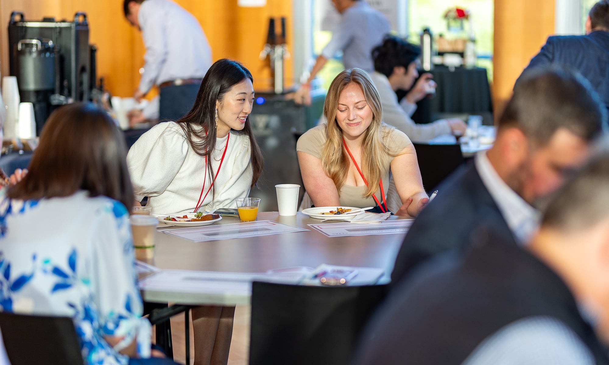 Two ReMix attendees share conversation at a table inside Knobel Hall